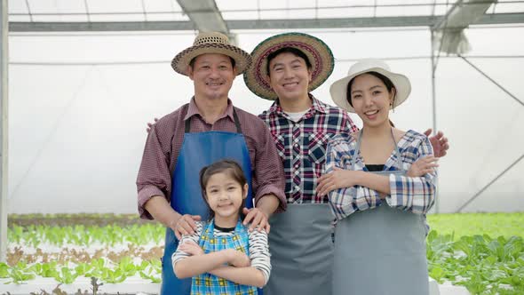 portrait of an Asian organic vegetable farmer family is standing and smiling confident