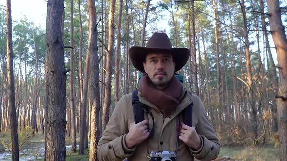 A Man with Camera Walks Along a Trail in the Forest alt