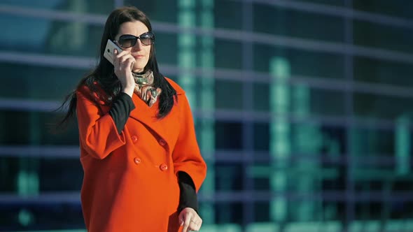 Beautiful Girl in a Red Coat Talking on the Phone alt