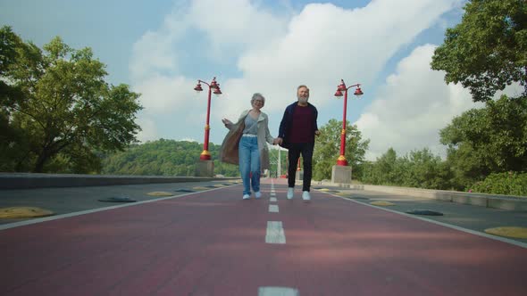 Happy Aged Couple Having Fun and Hanging in Summer Park alt