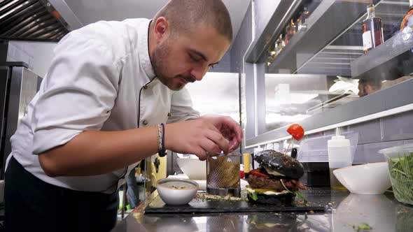 Cook in Restaurant Kitchen Placing Fried Potatoes alt