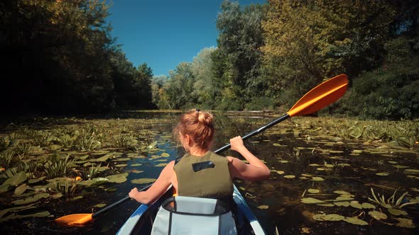 Traveller Girl In Life Vest Swims In Kayak Boat In Tranquil Pond.Woman Exploring Calm River By Canoe alt