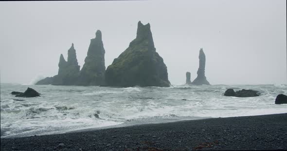 The Black Sand Beach of Reynisfjara with Waves Hitting the Shore on Foggy Rainy Stormy Day alt