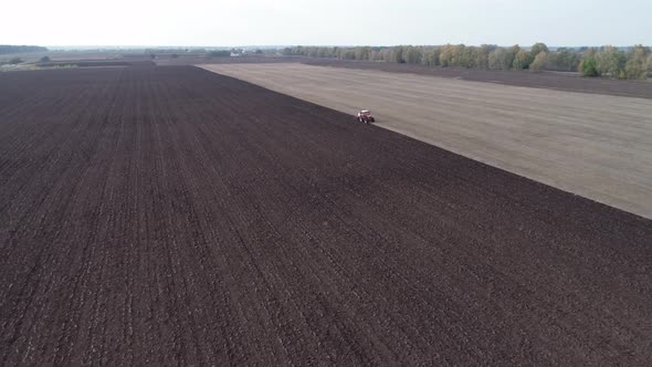 Agricultural Red Small Tractor in the Field Plowing alt
