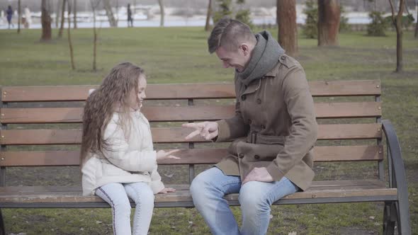 Cheerful Curly-haired Girl Playing Rock-paper-scissors Game with Father in City Park. Happy Young alt