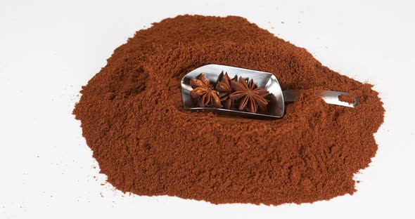 Star Anise illicium verum,, spice falling on Powder of Star Anise against White Background alt