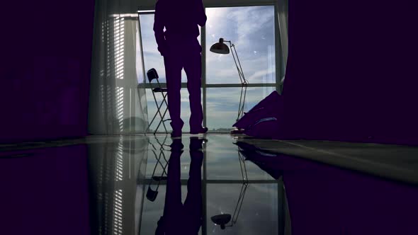Silhouette of an Young Man That Is Talking at Phone and Walking Inside the Business Building
