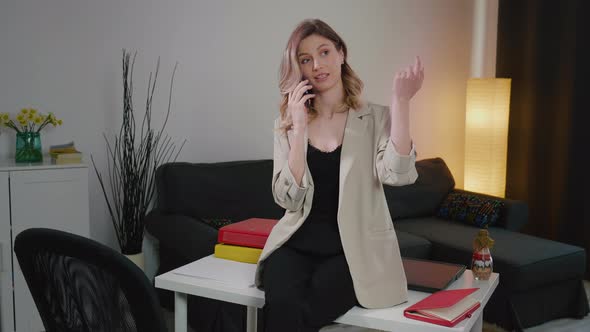 Happy Caucasian business woman explaining on the phone. alt