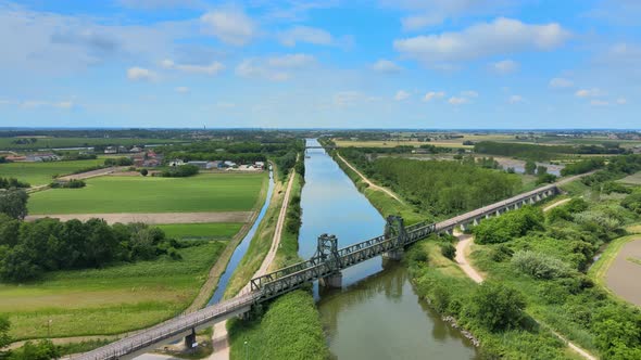 Flying above River and Metal Train Bridge alt