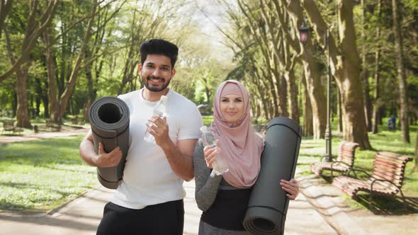 Charming Woman in Hijab and Handsome Muslim Man Standing Together Outdoors with alt