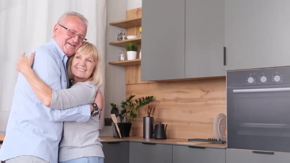 Grandparents Dancing at Home in the Kitchen They Laugh and Hug While Relaxing alt