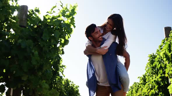Man giving piggy back to woman in the wine farm alt
