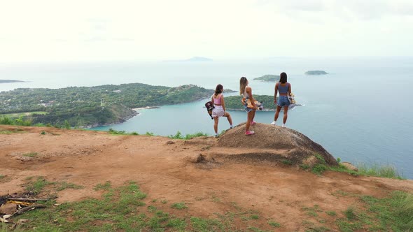 4K Aerial view group of Asian woman skating and hiking to mountain peak at tropical island. alt
