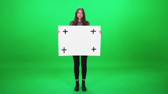 Protest Movement Female Activist Standing on the Green Background and Holds a White Paper Poster alt
