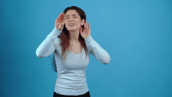The Portrait of a Rogant Girl Sitting with One Hand to Her Ear and the Other Showing the Sign That alt