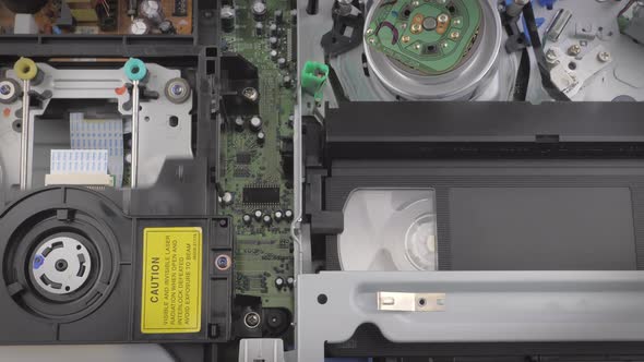 Interesting Shot of a Dvd and a Vhs Cassette Being Ejected Out of a Player alt