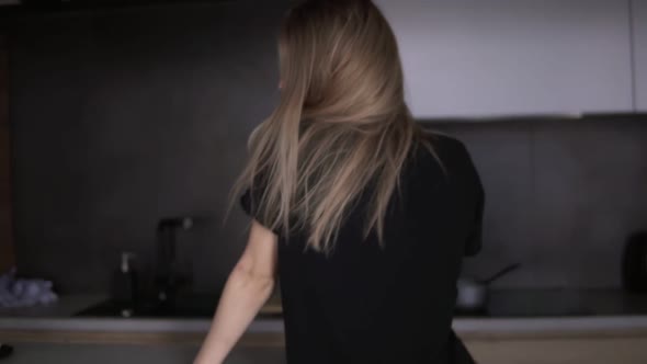 Slender Girl Dances Sensually in the Kitchen with Modern Loft Interior alt