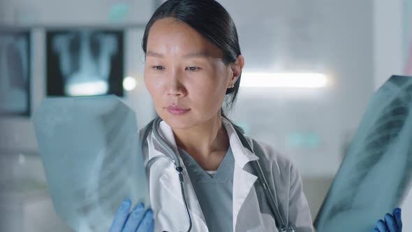 Asian Doctor Looking With X-ray Shots alt