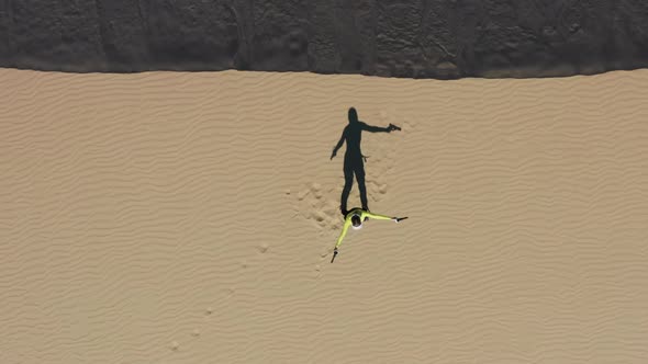 Excited Young Gamer Girl Staying on Sand Dune in Desert Playing Shooting Game alt
