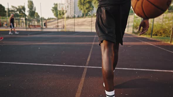Male Athlete Trains on the Basketball Court and Throws the Ball Into the Basket alt