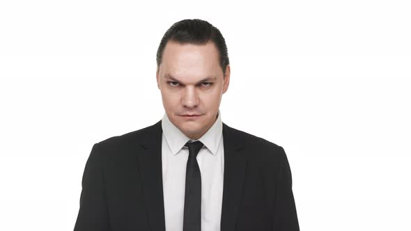 Portrait of Adult Man in Classic Black Suit Smirking and Behaving Sarcastically Over White alt