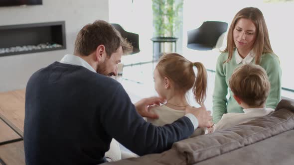 Happy family with two kids enjoy time together on couch in living room