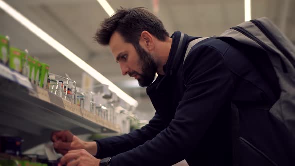 Shopping In Hypermarket Mall On Electronic Device Store Section. Man In Market Choosing Led Lamp. alt