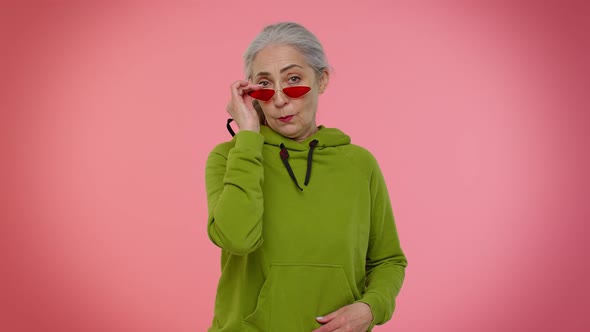 Happy Playful Stylish Senior Granny Woman in Sunglasses Blinking Eye Looking at Camera with Smile alt