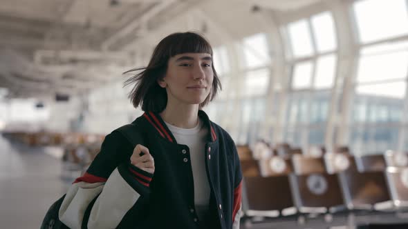 Young Stylish Woman Carrying Black Backpack at Airport alt