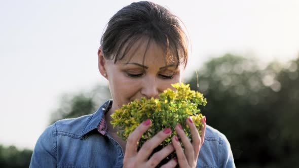 Portrait of Middle Aged Woman with Fresh Cut Flowers of St alt