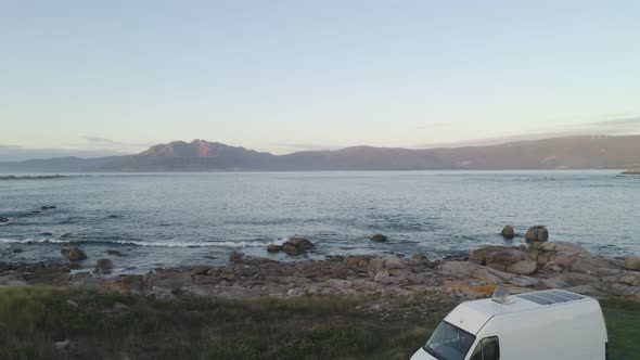 Camper van motorhome drone aerial view on a sea landscape with mountains living van life in Spain alt