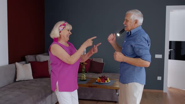 Senior Couple Dancing Laughing at Home. Grandparents Relaxing Having Fun Celebrating Anniversary alt
