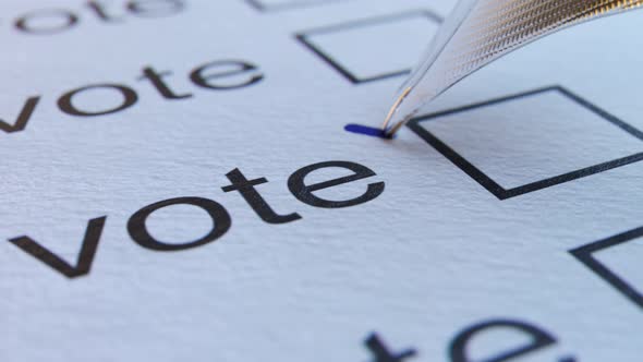 Close up of a quill pen making a check sign with ink in an empty bracket. Voting