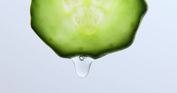 Gel, juice drips from cucumber slices with gel on white background