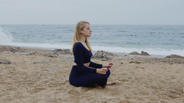 Young Woman Has Yoga Workout On Ocean Coast