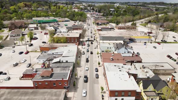 Aerial descend flyover downtown of Grimsby during many cars passing road in summer,Canada. alt