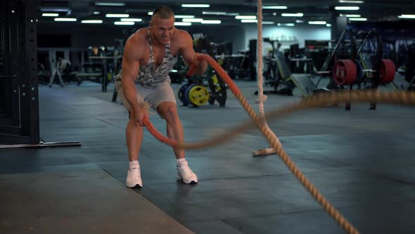 Muscular Athletic Bodybuilder Fitness Model Training Battle Rope Gym alt