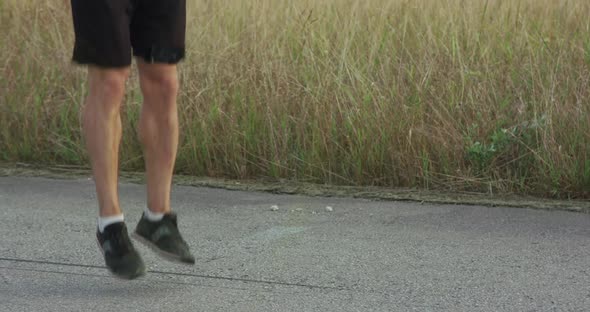 Kickboxer Doing Fast Jumps on Skipping Rope on Walkway Outdoors alt