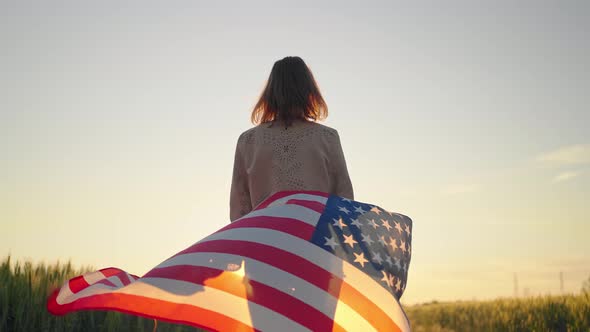 Slow Motion Rear View of Young Beautiful Sexy American Woman Holding a American Flag Walking Wheat alt