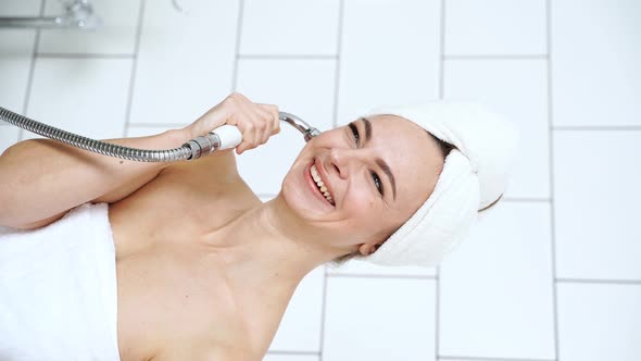 Young Woman in Bathroom Talking By Watering Can