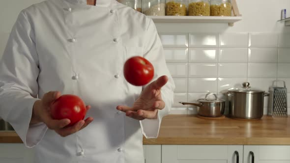 Chief-Cooker Juggles A Red Tomatoes In A Kitchen
