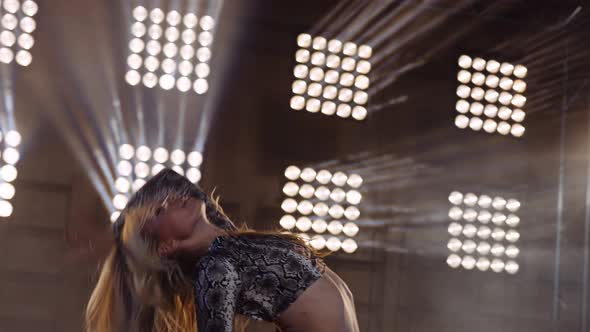 Woman Staring Straight at the Camera Performing with Enthusiasm on Stage alt