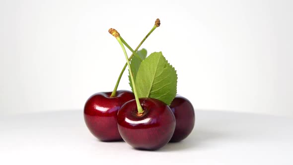 Ripe sweet cherry rotating on white background