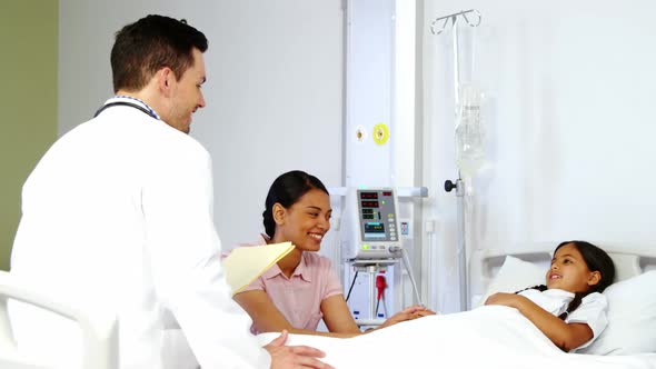 Mother comforting a daughter and talking to doctor alt