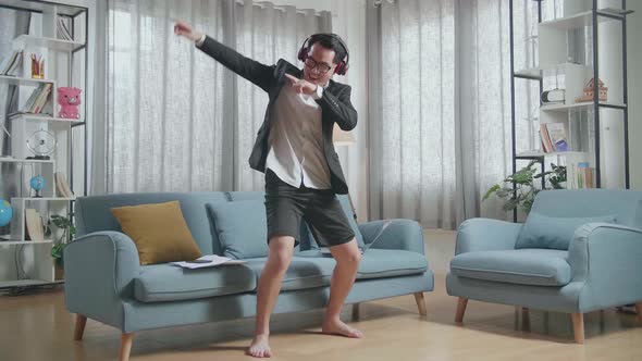 Full View Of Asian Businessman In Jacket And Shorts Listening To Music With Headphones And Dancing alt