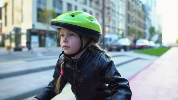 Cute Female Child in Safety Helmet Sitting on Bicycle, Ready to Ride on Street