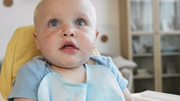 Joyful Toddler Sitting at High Chair alt