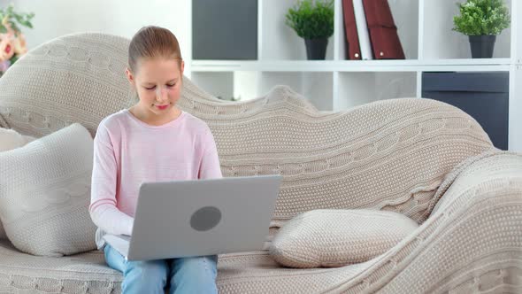 Focused Beautiful Child Girl Chatting in Social Network Typing Message Using Laptop Pc Medium Shot alt