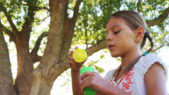 Girl blowing bubbles through bubble wand alt