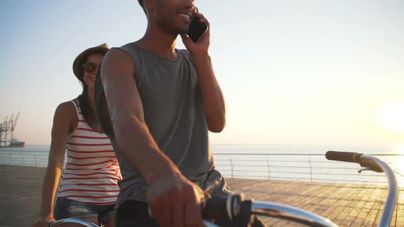 Portrait of a Mixed Race Couple on Tandem Bicycle Outdoors Near the Sea Young African Black Man alt